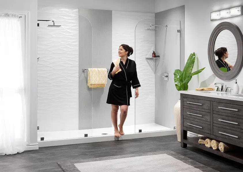 Woman in modern bathroom with glass shower