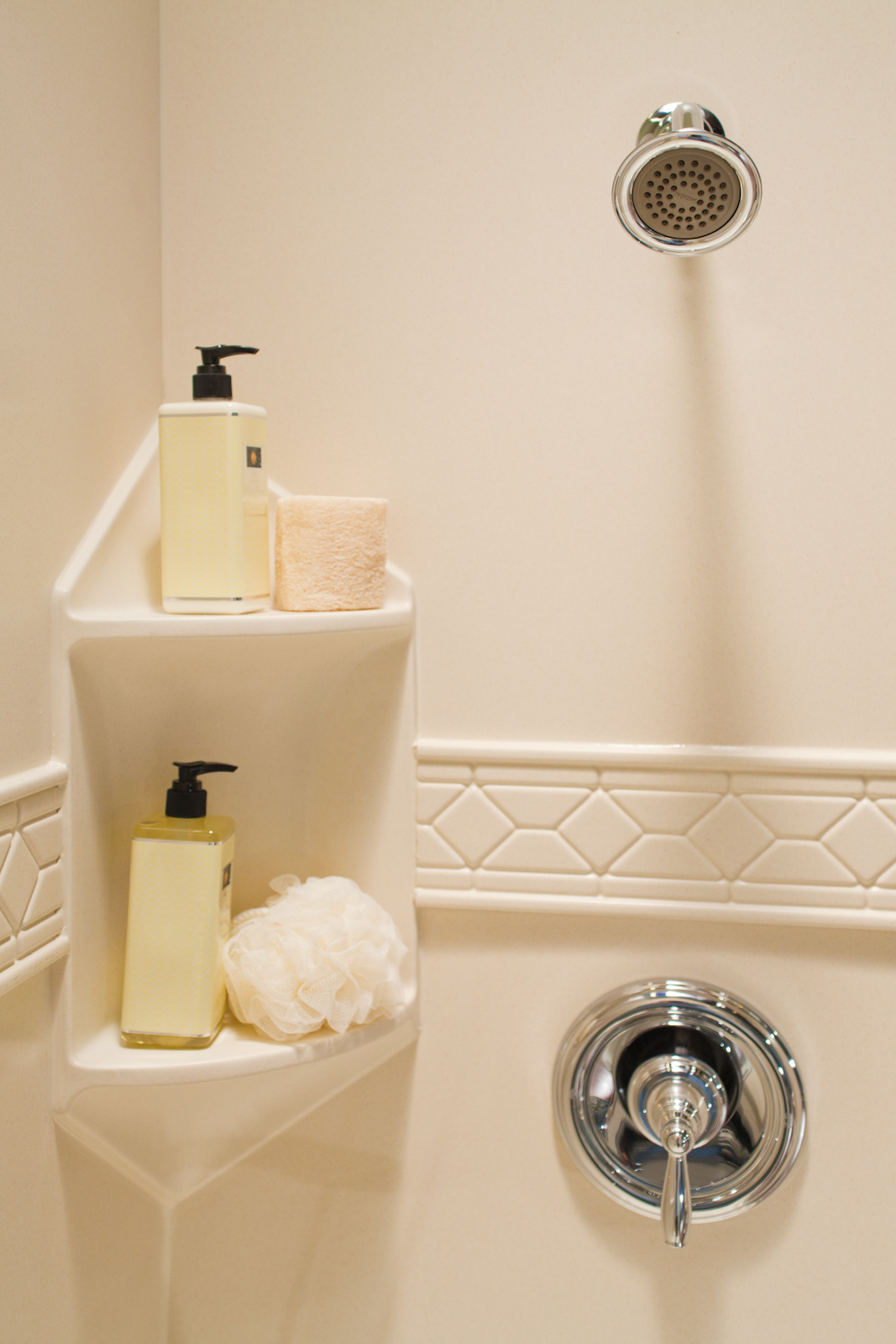 Biscuit two-shelf corner caddy in beige granite smooth wall with listello trim