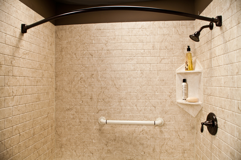 Corner caddy and grab bar in brecchia subway walls with oil-rubbed bronze fixtures
