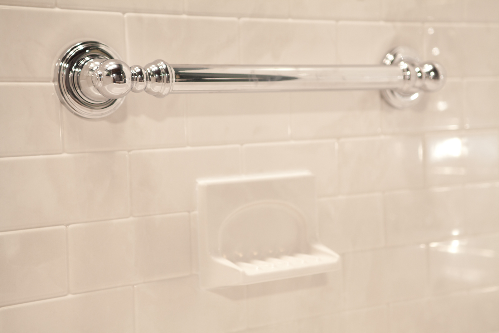 Chrome Chateau grab bar with soap dish on silver white subway walls