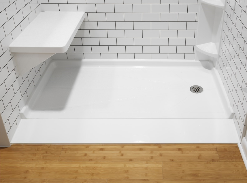 Ultra low shower base with fold-down seat and corner shelf on white subway tile walls