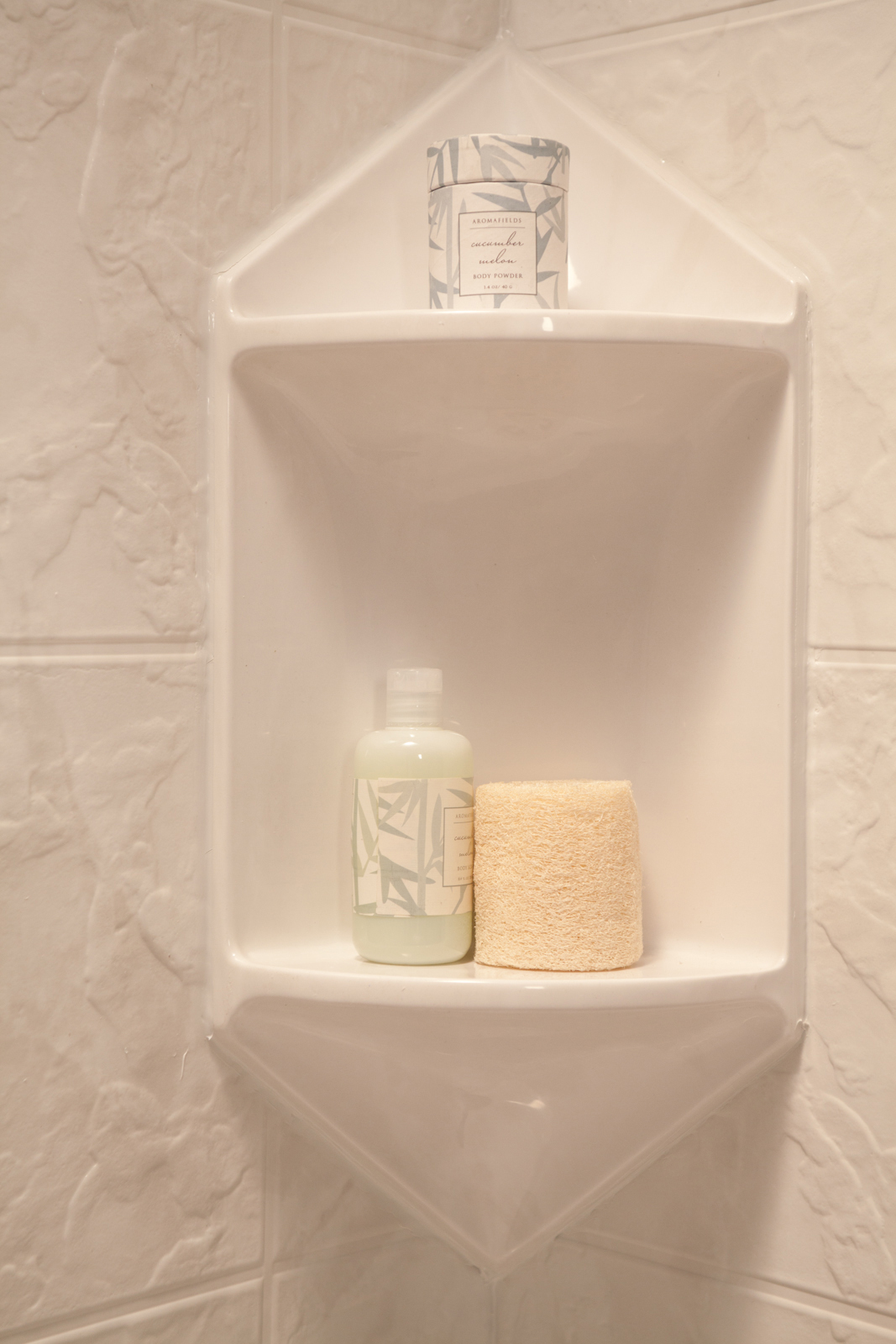 White two-shelf corner caddy on white 12x12 tile wall