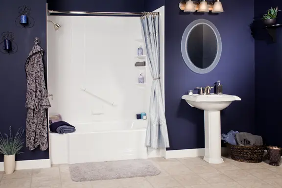 White tub and shower combo in navy blue bathroom